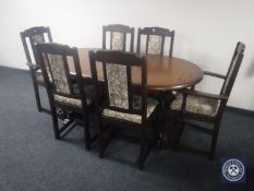 An oval oak extending dining table and six tapestry chairs