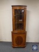 An inlaid yew wood corner cabinet