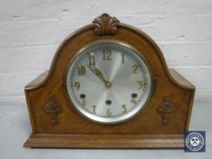 An early 20th century oak mantel clock with silvered dial