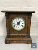 A carved oak cased bracket clock with enamelled dial,