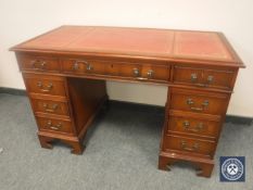 A reproduction twin pedestal desk fitted with nine drawers and tooled leather top, width 122 cm.