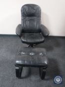 A late 20th century black swivel armchair and similar footstool