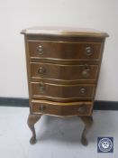 A mahogany serpentine-fronted four-drawer bedside chest on Queen Anne style legs