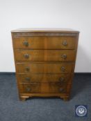 A mid 20th century walnut five drawer chest