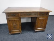 An early 20th century continental oak twin-pedestal desk