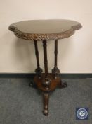A late Victorian carved mahogany occasional table, height 72 cm.