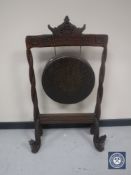 An early 20th century Indonesian dinner gong in carved frame