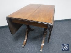 A 20th century walnut pedestal drop leaf table