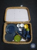 A wicker picnic basket containing English and continental plastic table ware