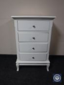 A contemporary white four drawer chest
