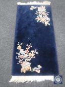A blue fringed Chinese hearth rug