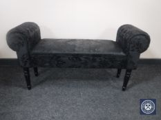 A contemporary window seat upholstered in a black fabric