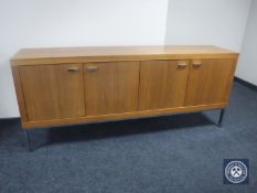 A contemporary four-door sideboard in a walnut finish on metal legs