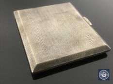 A silver cigarette case with engine-turned decoration,
