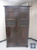 A late Victorian oak double door wardrobe with two carved panels CONDITION REPORT: