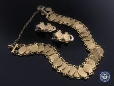 A yellow metal coin bracelet with matching earrings