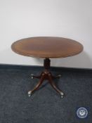 A reproduction mahogany oval pedestal wine table
