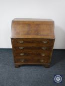 A walnut writing bureau on bracket feet