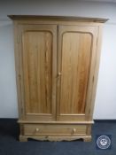A pine double door wardrobe fitted a drawer