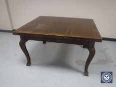 A late Victorian oak extending dining table on claw and ball feet