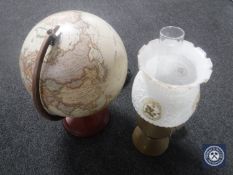 A converted brass oil lamp with brass chimney and shade and an illuminated globe