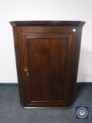A George III mahogany hanging corner cupboard