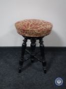 A circular Victorian adjustable piano stool
