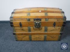 A wooden and metal domed topped shipping trunk