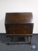 An early 20th century oak bureau on barley twist supports