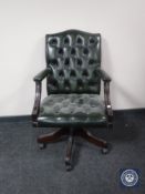 A green button leather Chesterfield revolving office armchair (lacking one caster)