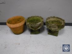 A pair of classical stone garden planters together with a terracotta planter
