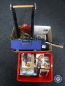 Two boxes containing paperback and hardback books including Westerns, two badminton rackets,