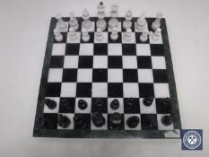 A marble chess set together with a boxed dart board with darts