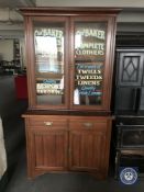 A Victorian and later glazed mahogany bookcase with later advertising writing,