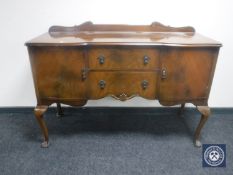 A 20th century walnut serpentine fronted sideboard on Queen Anne legs