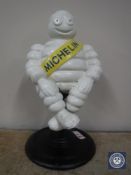 A cast metal figure of a seated 