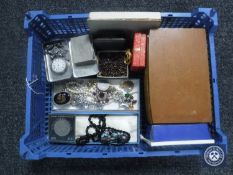 A basket containing a large quantity of assorted costume jewellery, simulated pearls, travel clock,