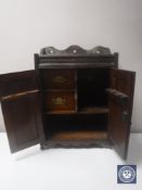 A Victorian oak double door smoker's cabinet with carved panel doors