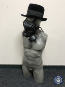 A male mannequin torso with hat and gas mask