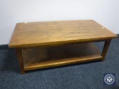 A cotemporary two-tier coffee table with rattan undershelf