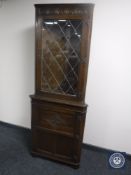 An oak leaded glass door corner cabinet
