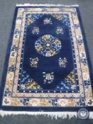 A fringed Chinese rug on blue ground