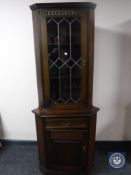 An oak leaded glass door corner cabinet