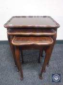 A nest of three mahogany pie crust edge tables