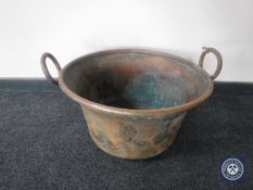 A large antique copper twin handled cooking pot