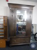 An Edwardian oak mirror door wardrobe