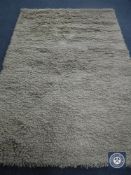 A hand knotted shaggy beige rug, 180 cm x 270 cm, rrp £681.