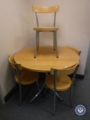 A kitchen table on metal base with four chairs