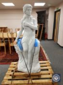 A contemporary carved solid white marble statue of a semi-nude female seated on a rock holding a