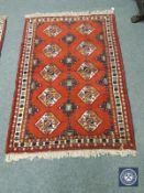 A Caucasian design rug on red ground,